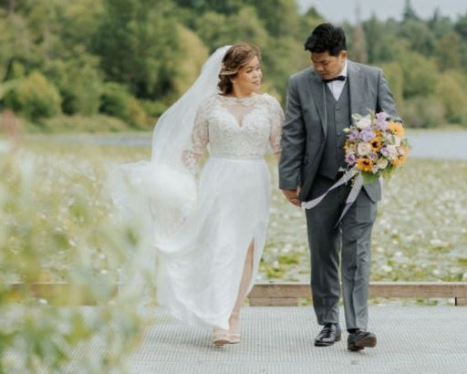 Couple in wedding attire walking together with a scenic background