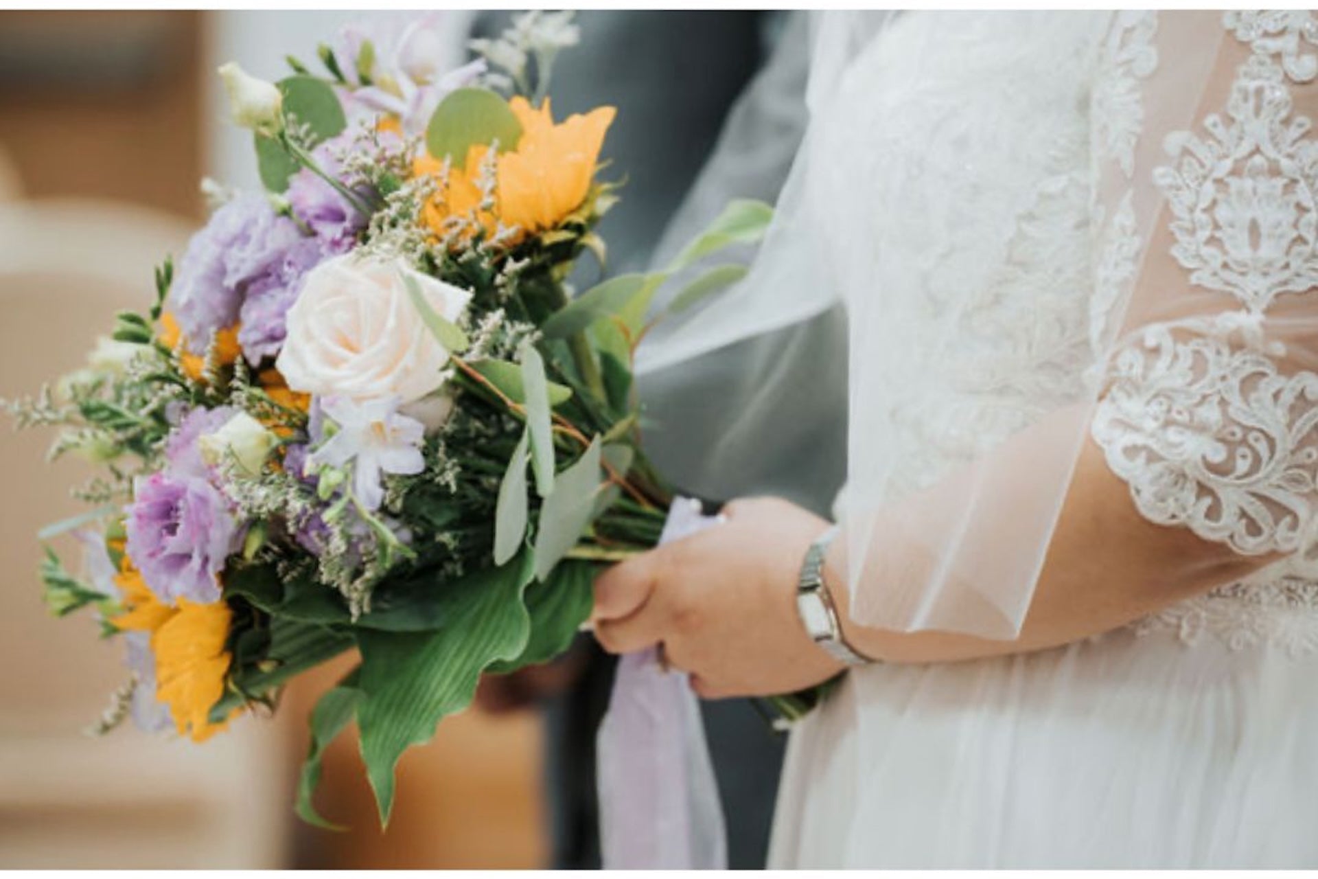 Bouquet of flowers held by a person wearing a lace dress.