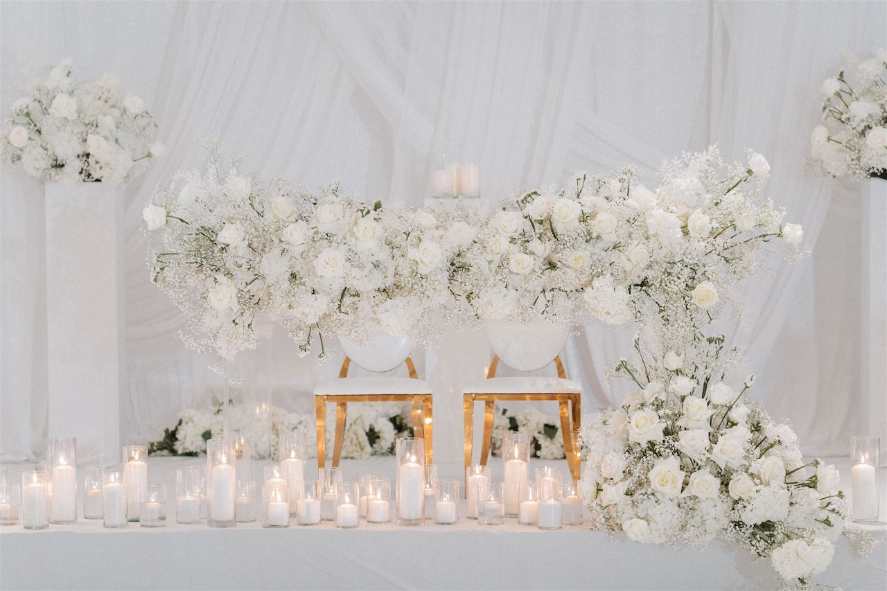 Decorative setup with white flowers and candles on a white background for wedding.
