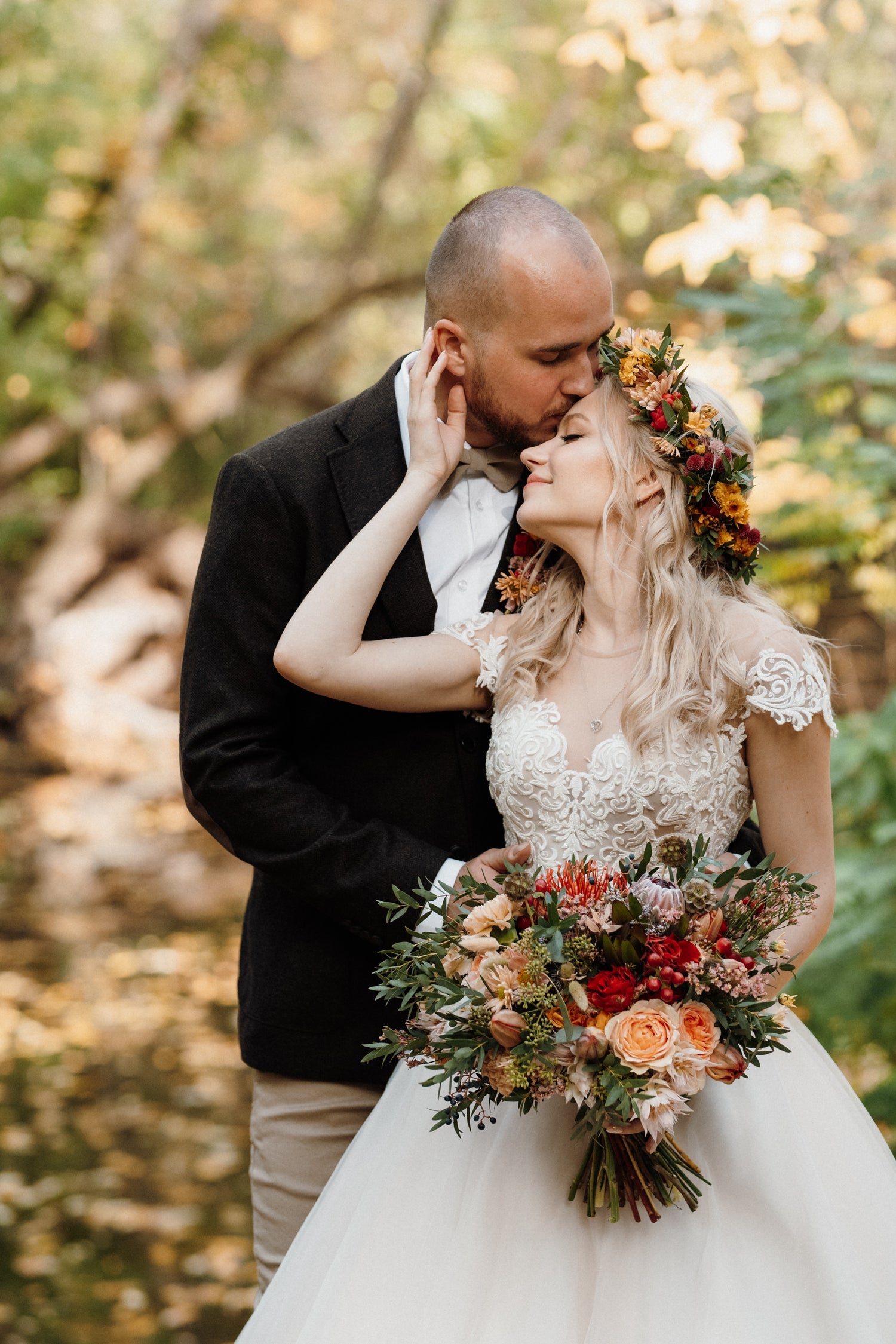 Couple in a forest setting with the bride holding a Boho and Wildflower Bridal Bouquet and wearing a floral crown.