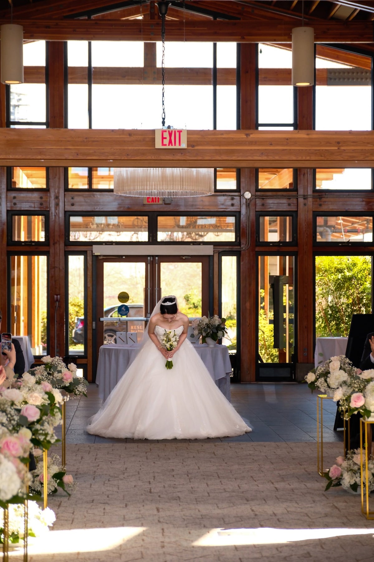 Romantic blush pink and white wedding ceremony arch with floral aisle arrangements at Riverway Clubhouse in Burnaby by Burst Flowers.