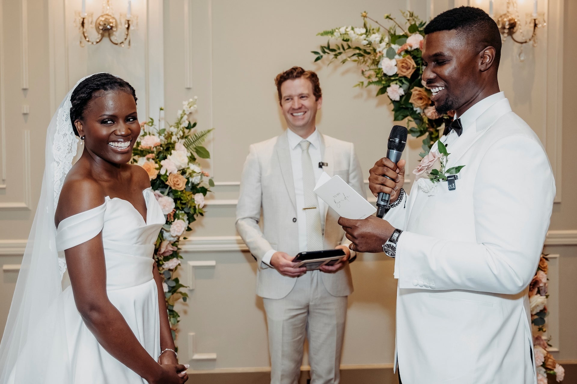 Wedding ceremony with a couple and officiant in a decorated indoor setting.