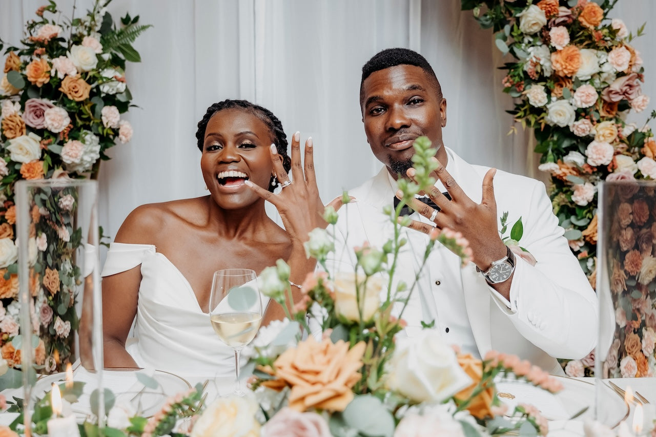 Couple at a wedding reception with floral decorations and table setting.