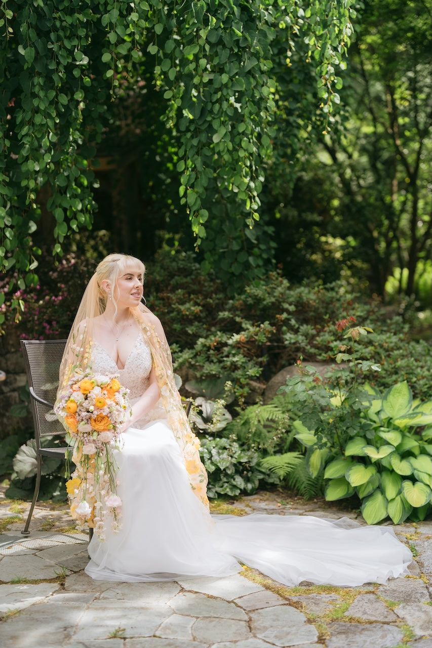 Bride in a garden setting with greenery and flowers.