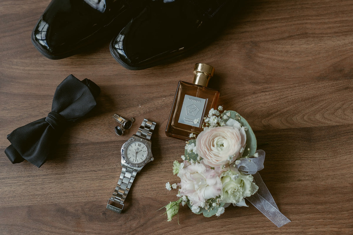 Delicate blush and white wedding boutonnière with ranunculus, baby's breath and eucalyptus greenery.