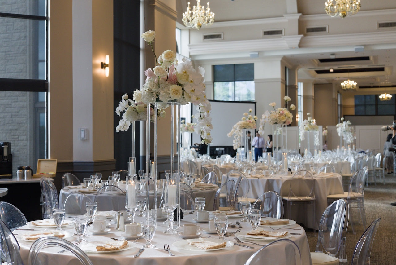 Decorated event space with tables set for a  wedding, featuring floral centerpieces and clear glassware at Swaneset Bay Resort & Country Club grand ball room.
