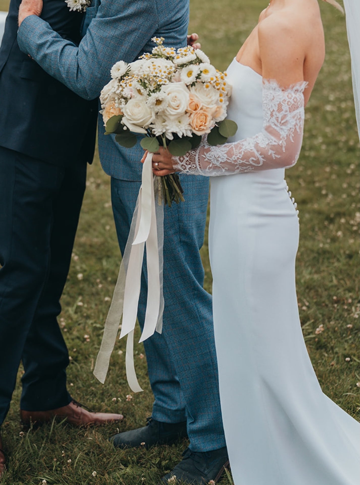 Bride holding a bouquet of flowers outdoors on a grassy field