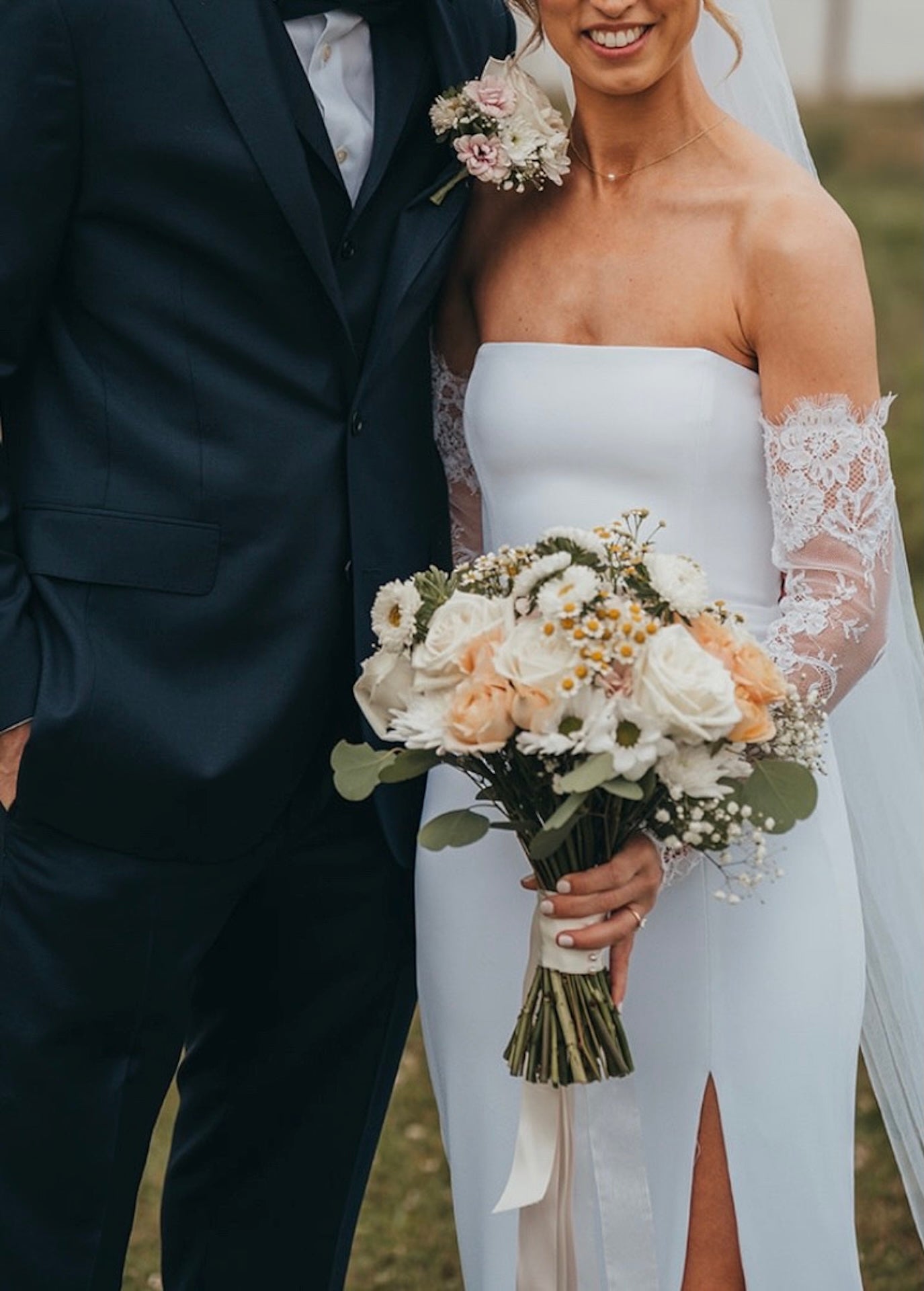 Couple in wedding attire with a bouquet of flowers.