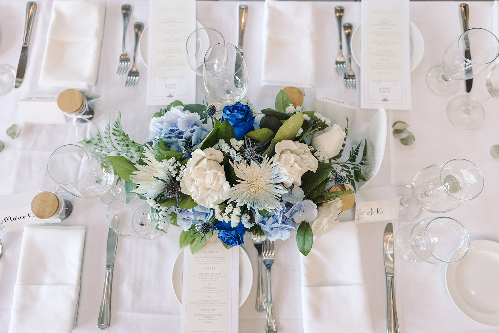 Elegant table setting with floral centerpiece on a white tablecloth.