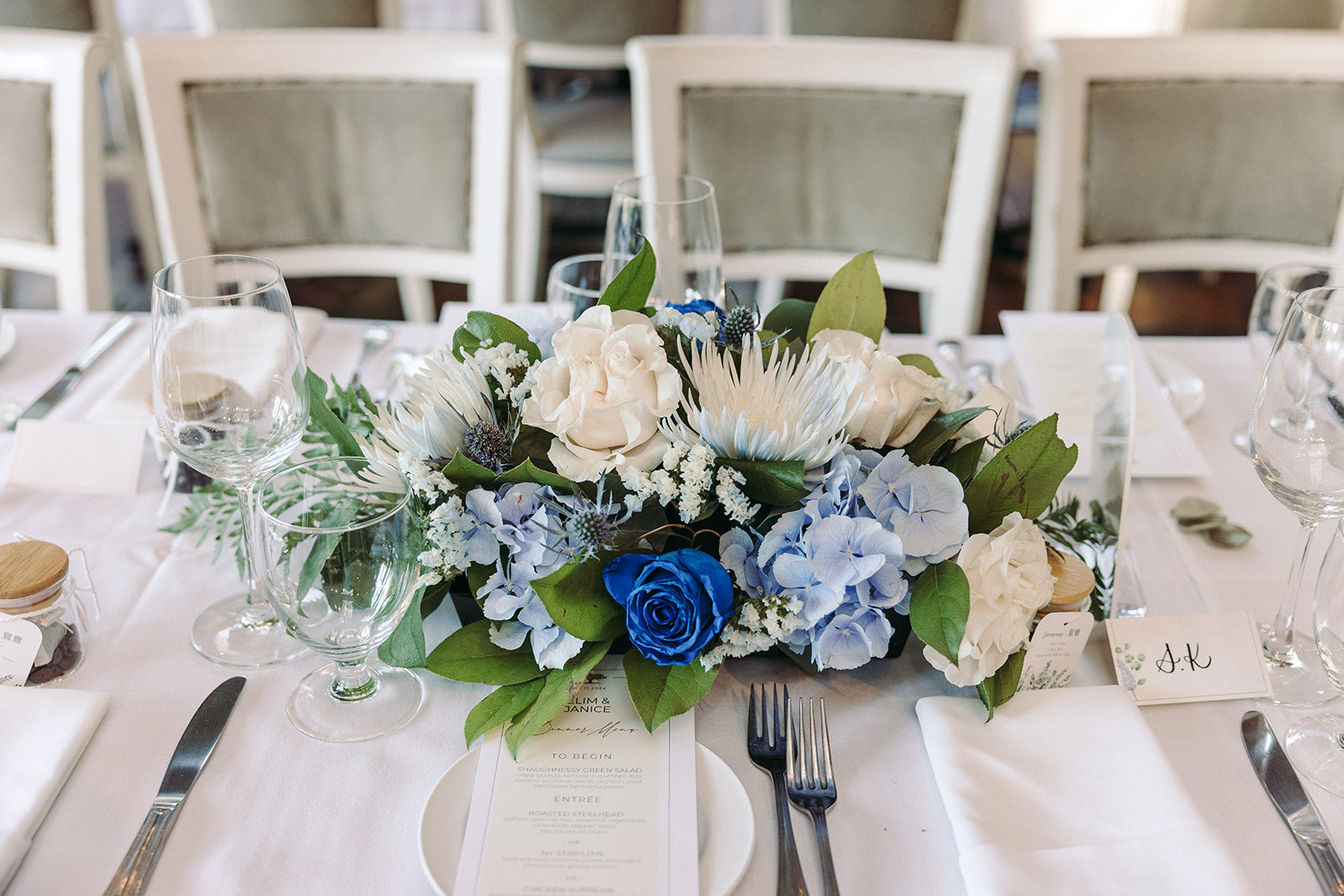Table setting with floral centerpiece and place cards in a formal dining setting.