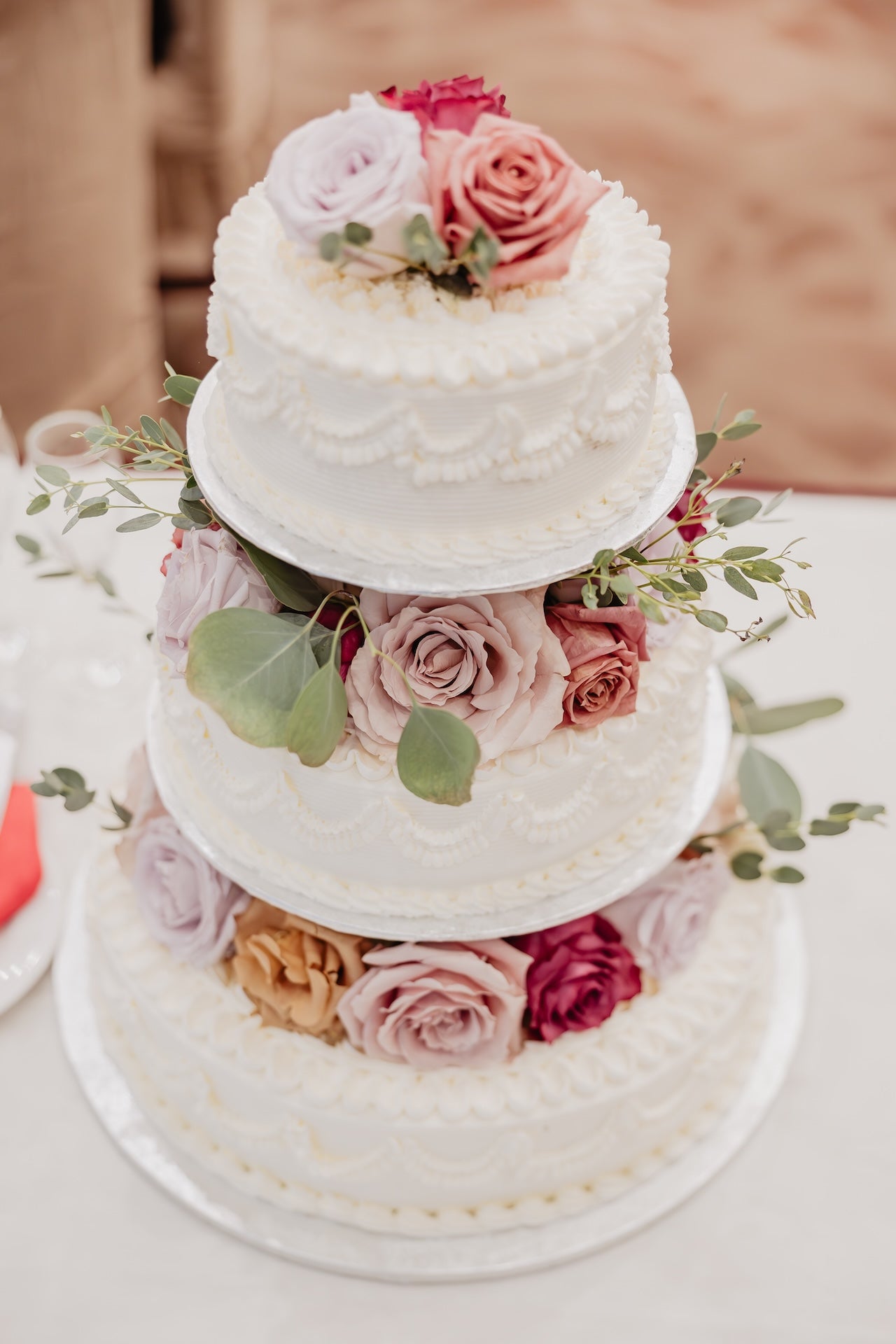 wedding cake decorated with fresh flowers and greenery