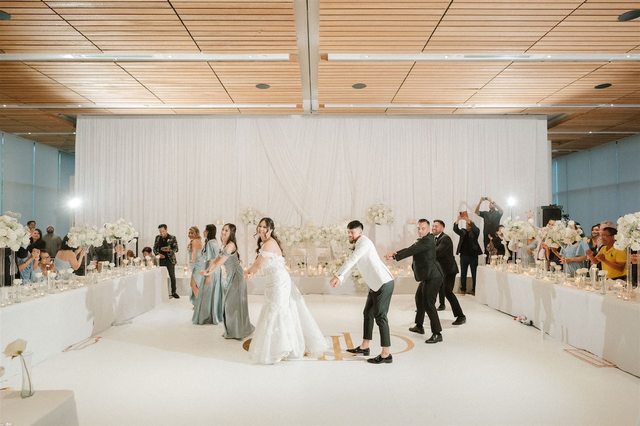 Wedding reception with guests and a couple in the center of the room.